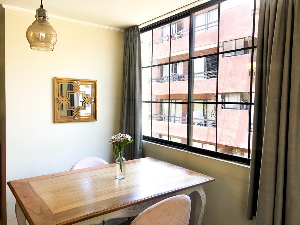 La imagen muestra un comedor con una ventana estilo francesa con cuadrículas negras.